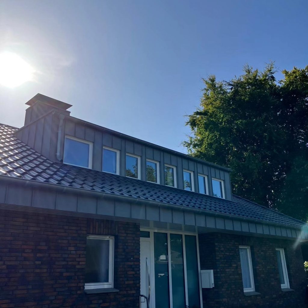 Tolle Dachgaube in Rheinzink vorbewittert eingebaut in ein Dach mit schwarzen Dachziegeln.