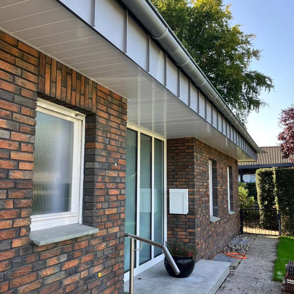 Dachrand und Dachrinne in Rheinzink vorbewittert. Untersicht mit weißen Profilbrettern.